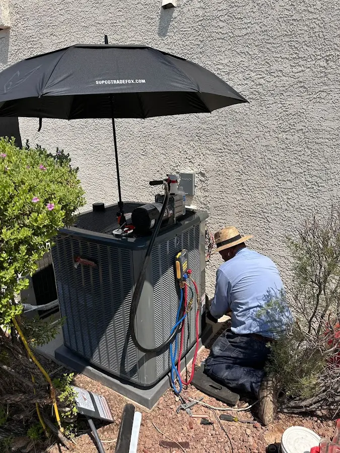 HVAC technician performing outdoor AC maintenance in Andover