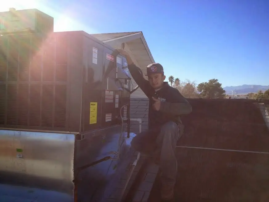 HVAC technician performing Heat Pump Repair on a rooftop unit in Andover